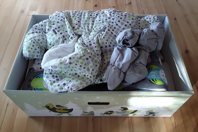 A 2017-es babakelengye kezeslábasa, kéz- és lábvédője, alatta a vastag lábzsák